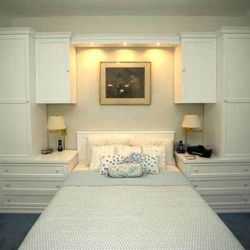 Спальня с навесными шкафами над кроватью