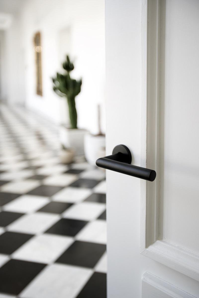 Черные ручки на белой двери