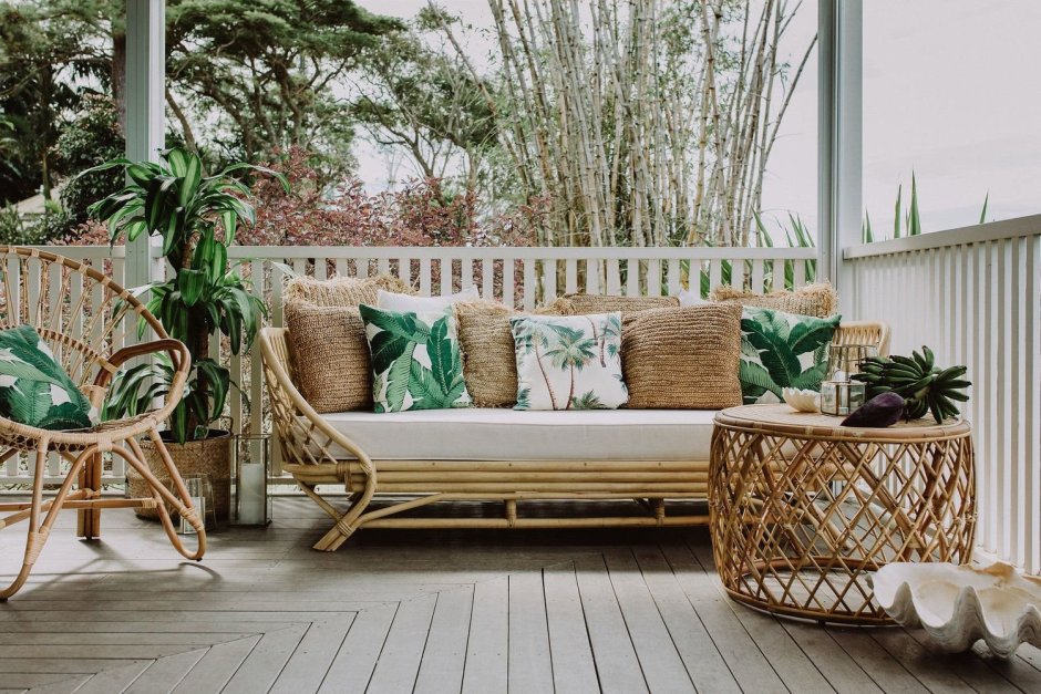 Красивый балкон с плетеной мебелью и цветами