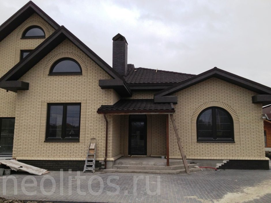 Дом из желтого кирпича с коричневой крышей