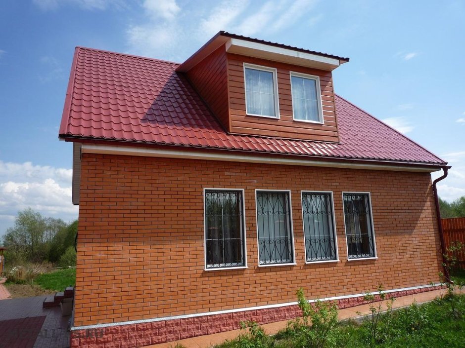 Кирпичный дом с бордовой крышей