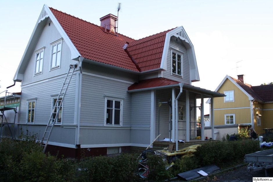 Серый дом с бордовой крышей