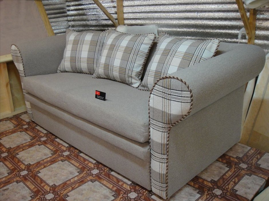 Старое мягкое кресло с деревянными подлокотниками