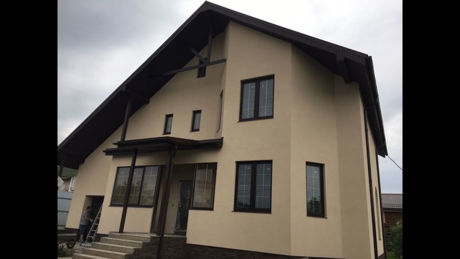 Оштукатуренный дом с коричневой крышей