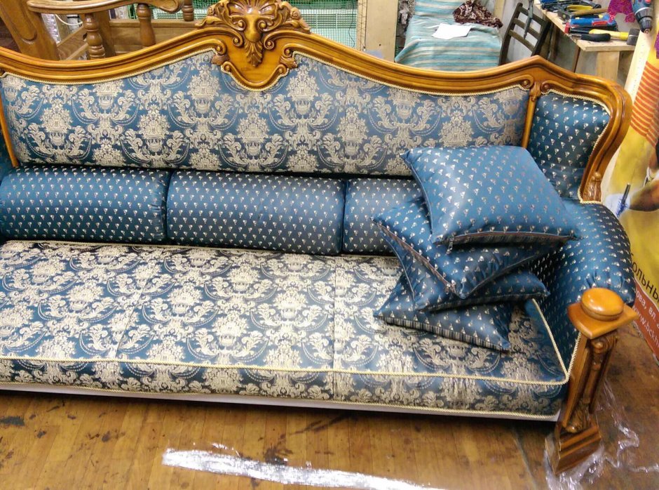 Диван с ковром на стене