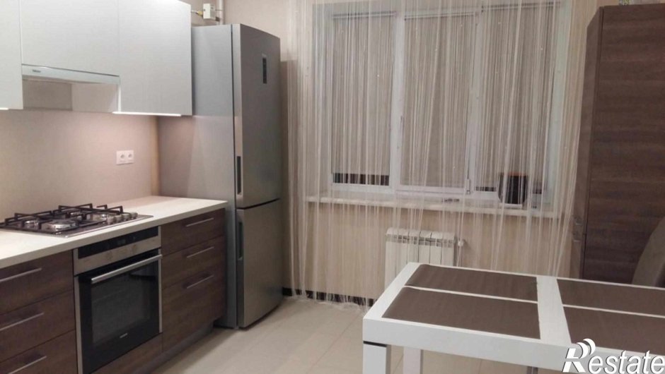 Холодильник возле окна на кухне