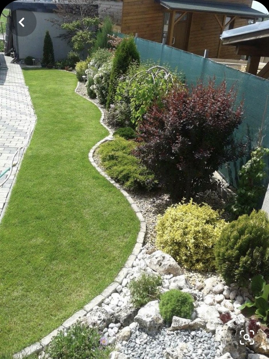 Клумбы вдоль забора на даче