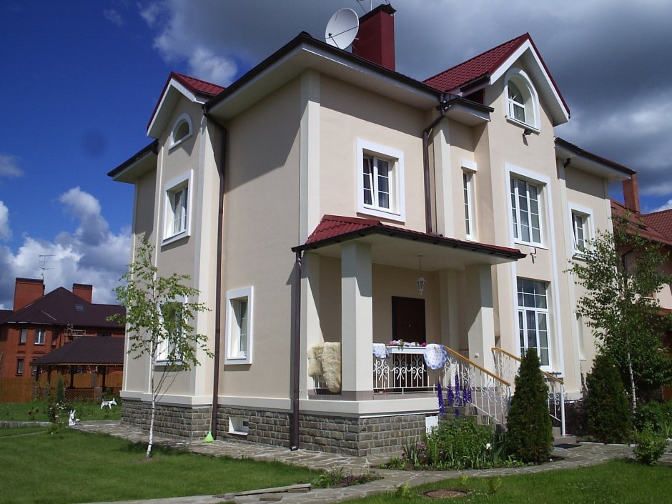 Оштукатуренный дом с красной крышей