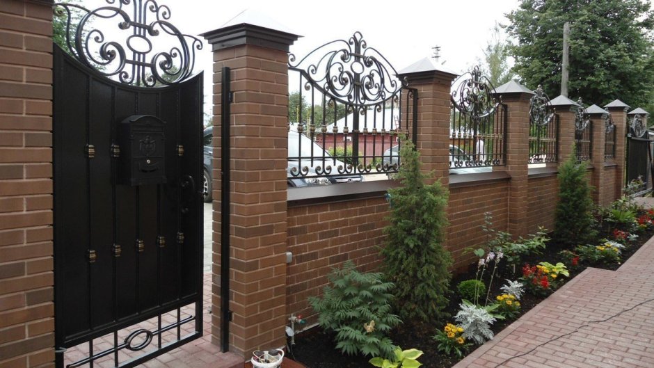Кованый забор с кирпичными столбами