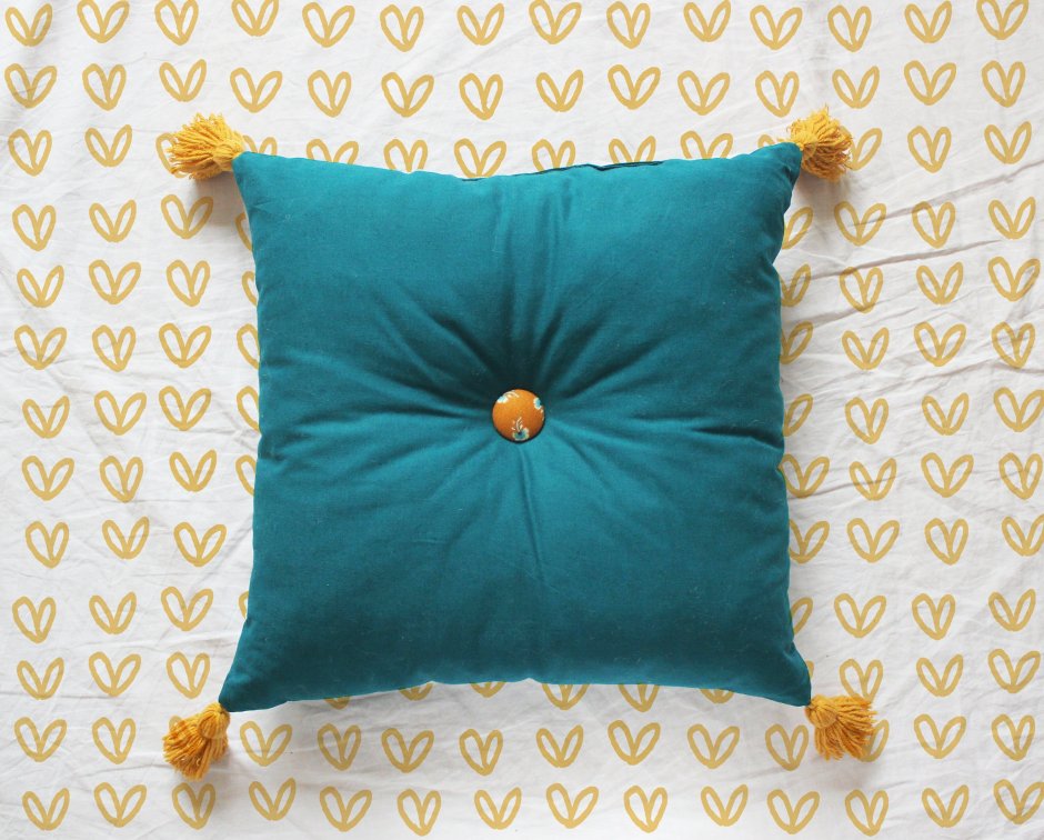 Желтая декоративная подушка с кисточками
