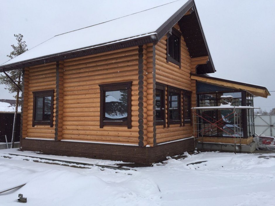 Коричневый бревенчатый дом с зеленой крышей