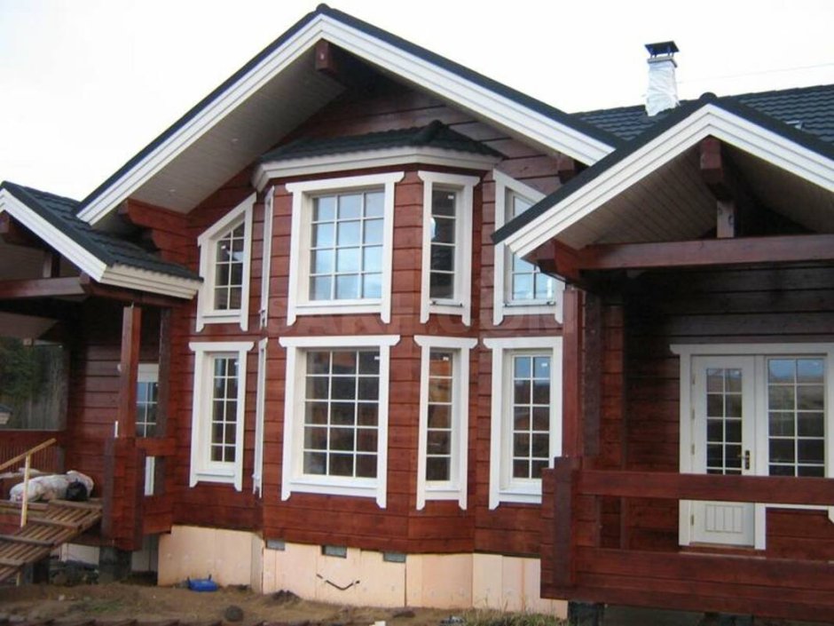 Коричневый деревянный дом с белыми окнами