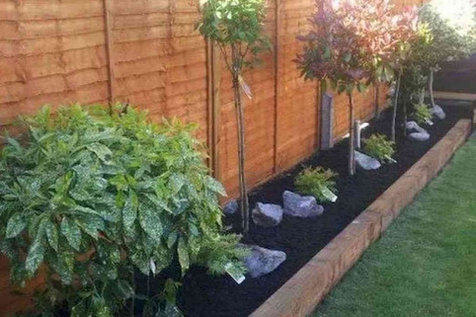 Клумба из кирпича вдоль забора