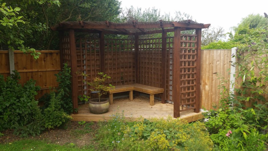 Пергола деревянная в углу участка