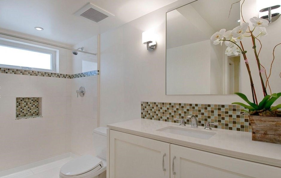 Ванная с белой плиткой и мозаикой